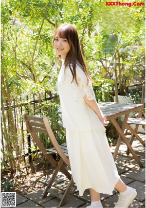 A young woman leaning against a railing with her hand on her chin.