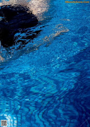 A woman in a black bikini in a swimming pool.