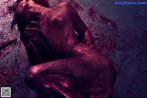 A naked woman sitting in a bathtub filled with foam.