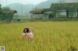 A naked woman standing on a wooden bridge.