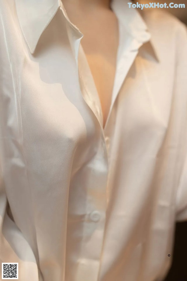 A woman wearing a white shirt with a plunging neckline.