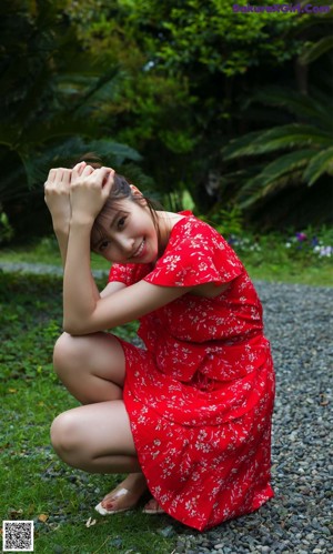 A woman sitting on a window sill in a black bathing suit.