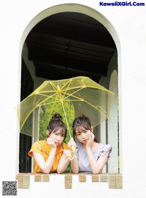 A couple of women sitting on top of a green couch.