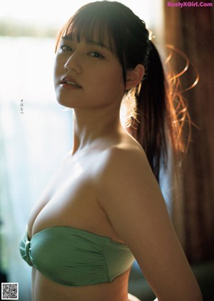 A woman in a red tank top posing for a picture.