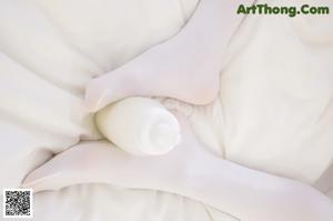 A woman is sitting in a bathtub with her legs up.