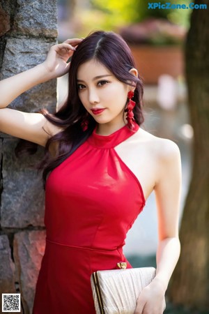 A woman in a red dress posing for a picture.