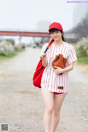 A woman in a red and white striped shirt and blue shorts.