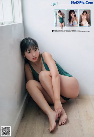 A woman in a green bathing suit laying on a couch.