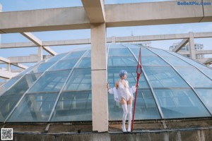 A woman in a white bodysuit holding a red sword.