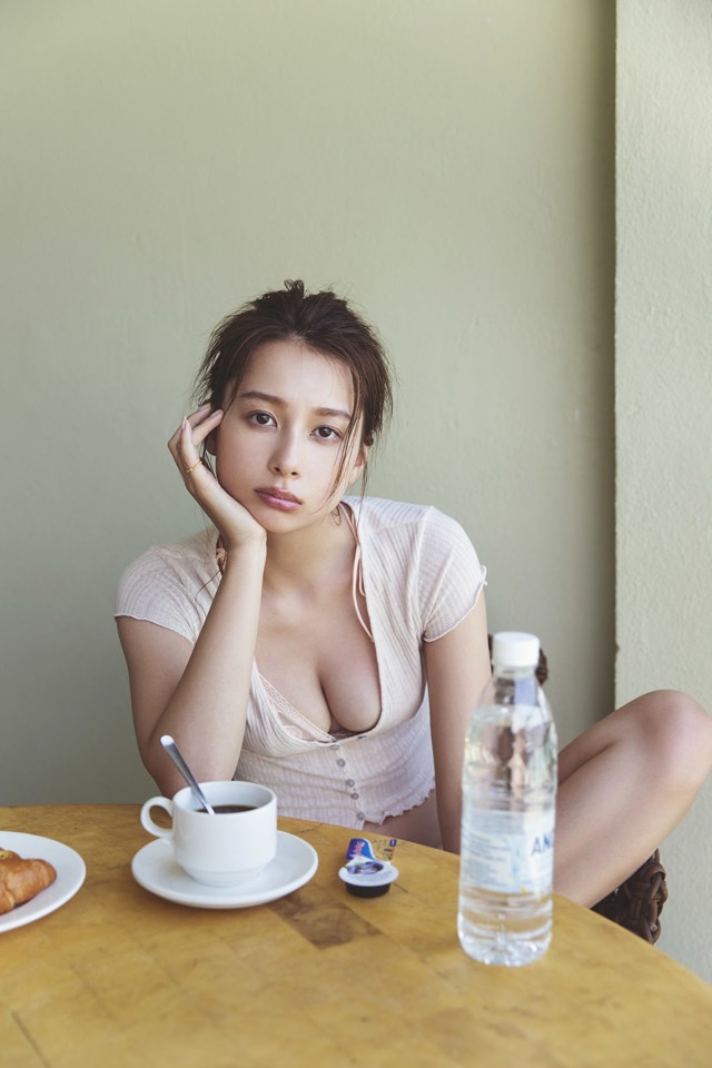 A woman sitting at a table with a cup of coffee.