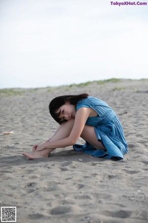 A woman in a blue dress posing for a picture.