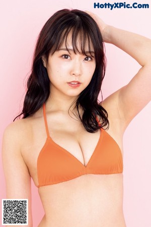 A woman in a white bikini posing with her arms crossed.