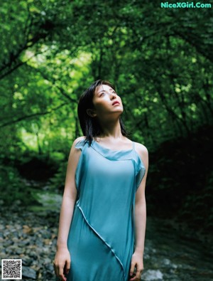 A woman in a white dress standing on a beach.