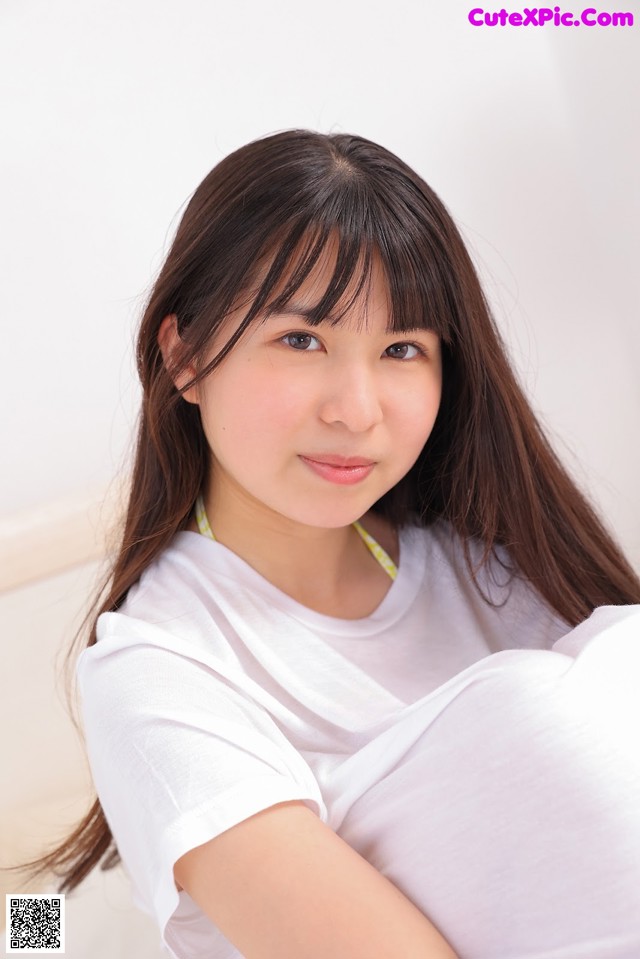 A woman in a white shirt is posing for a picture.