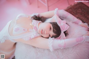 A woman sitting on top of a pink chair.