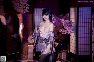 A woman in a kimono with a sword on the floor.