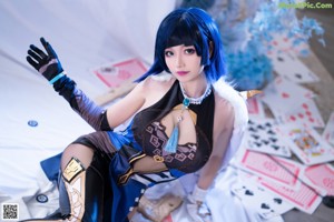 A woman in a blue and black outfit sitting on a table.