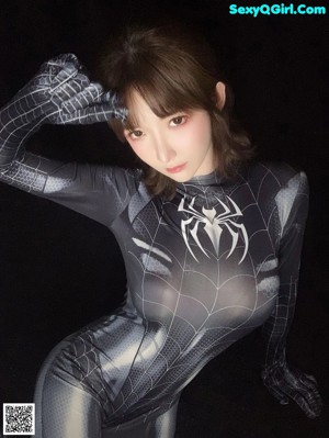 A woman in a black and white spider suit posing for a picture.