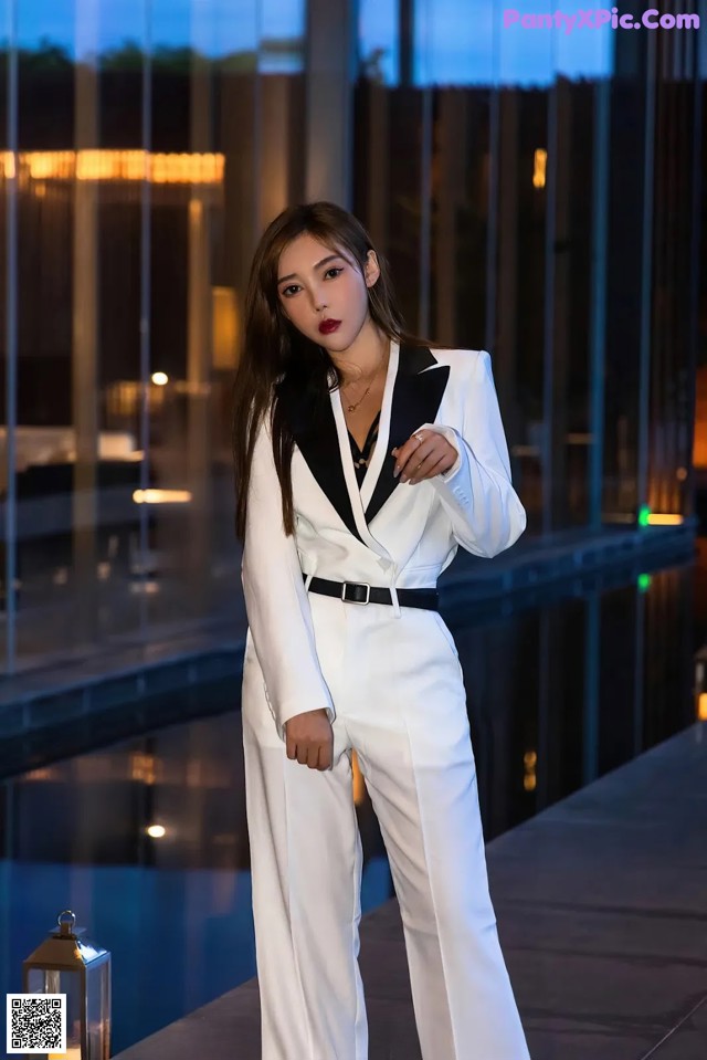 A woman in a white suit posing for a picture.