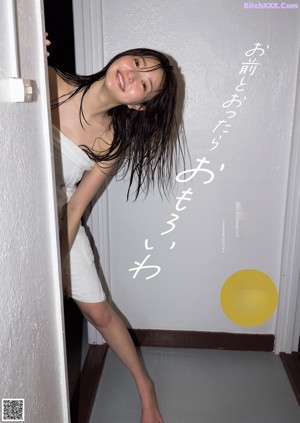 A woman with wet hair sitting in a bathtub.