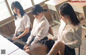 A group of young women sitting on top of a wooden floor.