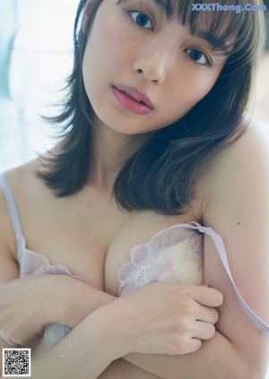 A woman in a nude bodysuit posing for a picture.